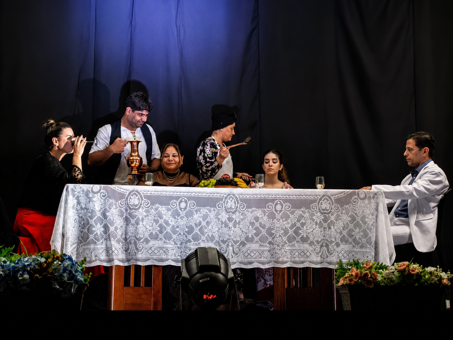 Cena de mesa com elenco em apresentação teatral